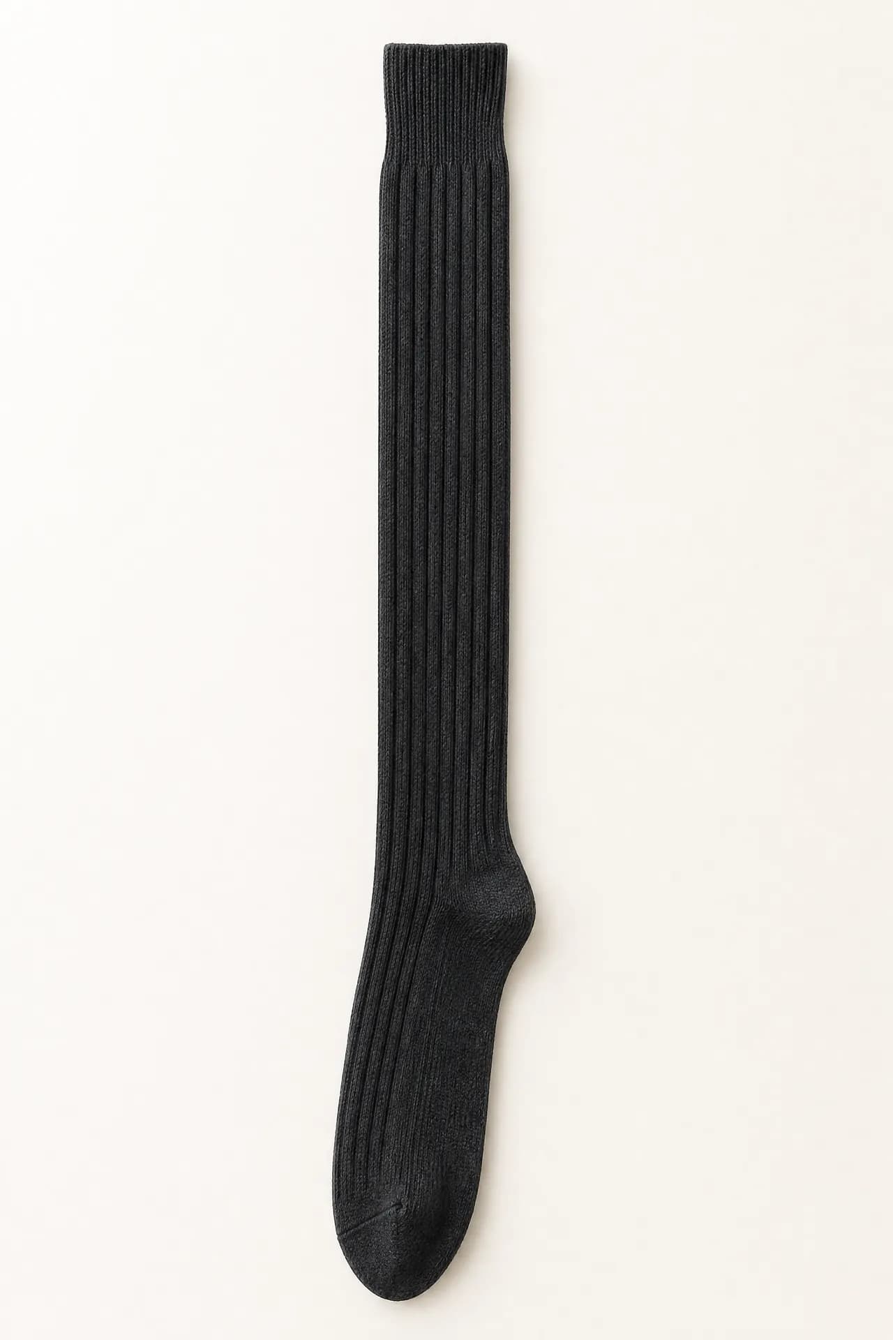 A single graphite ribbed sock hanging straight down the centre of a tall narrow frame, fully extended, its ribbed cuff at the top.