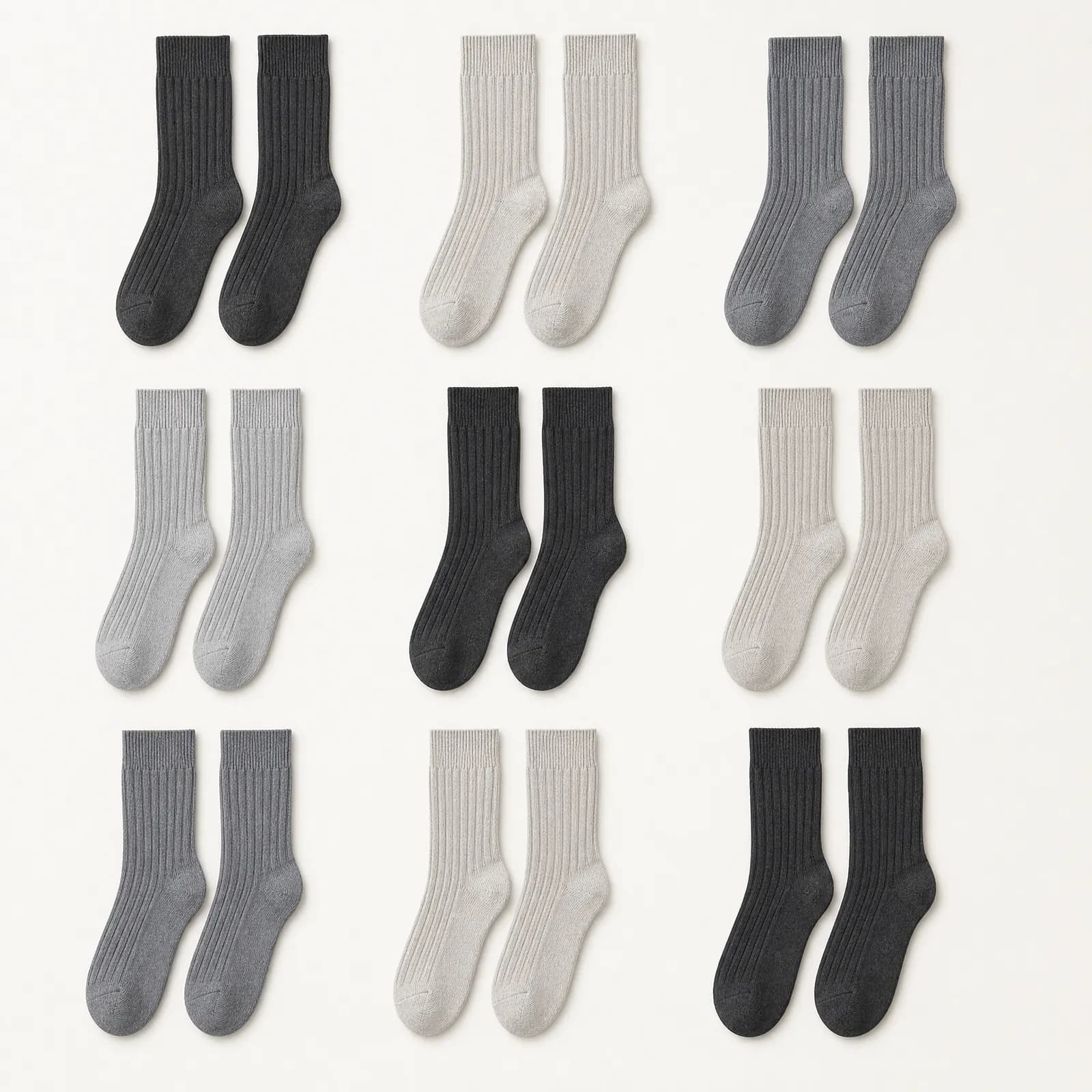 Nine pairs of ribbed socks laid flat in a three by three grid with wide even gaps, every pair fully extended.